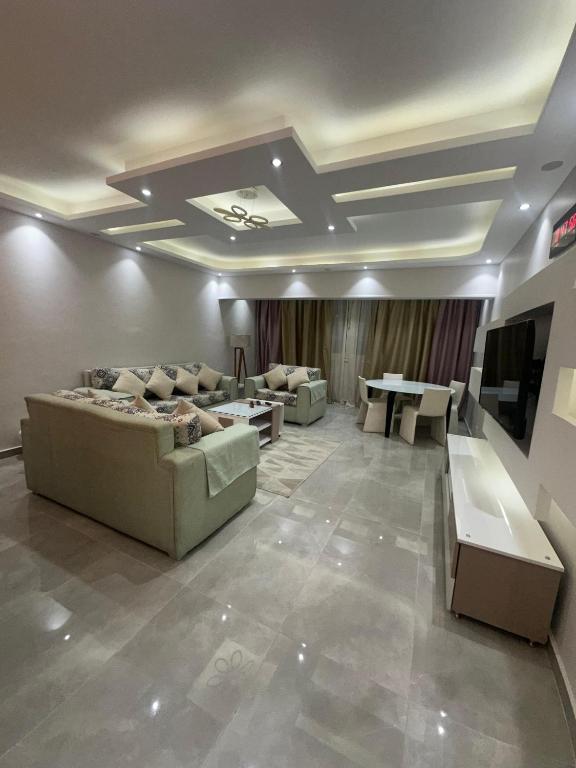 a living room with couches and tables and a tv at شقه مفروشه 3 غرف امام سيتي ستارز in Cairo