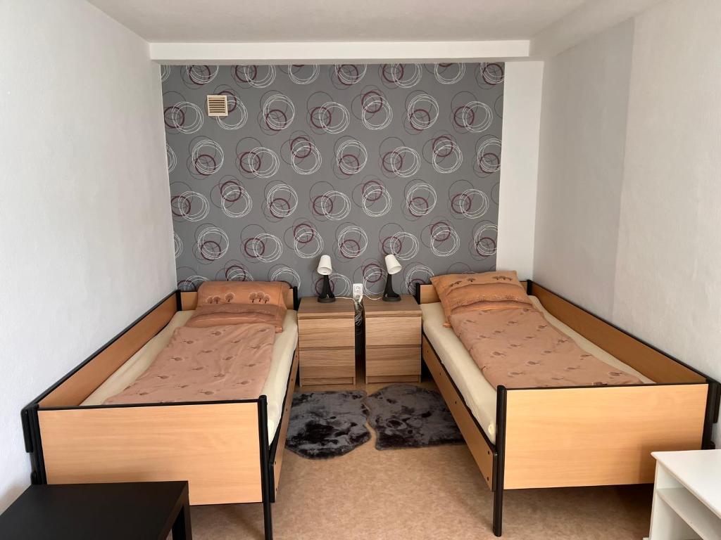 a room with two beds and a wall with plates at Ferienwohnungen Im Hirschgrund in Frohnhausen