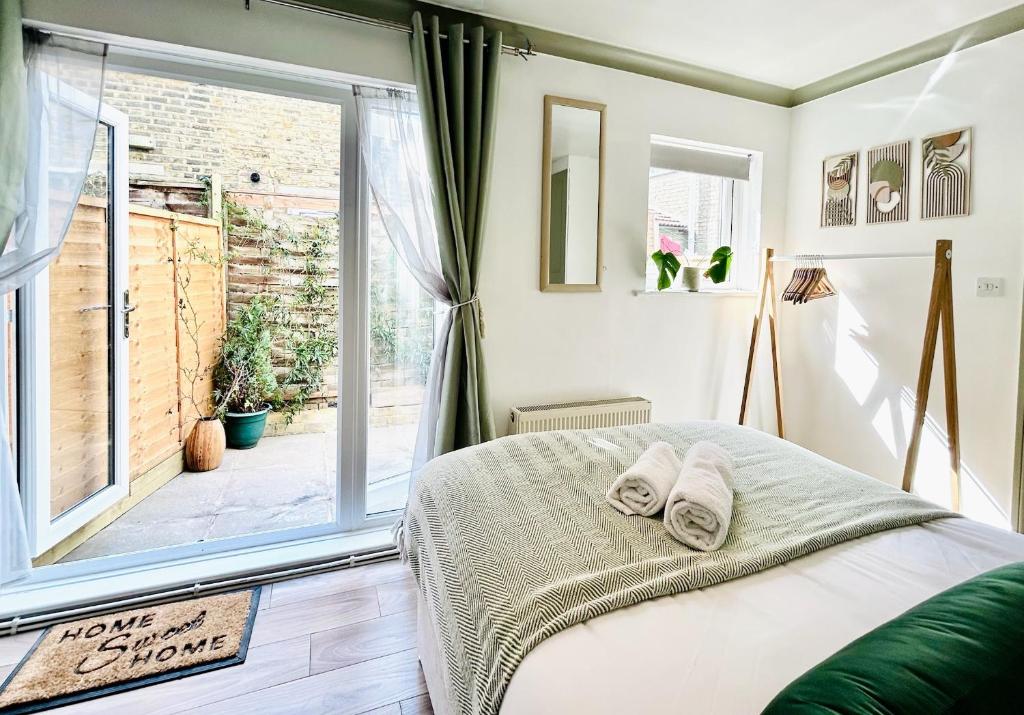 a bedroom with a bed and a large window at Courtyard Oasis in London