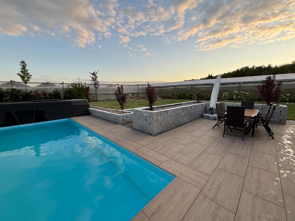 a patio with a pool and a table and chairs at Ferienhaus mit privatem Pool in Soltau
