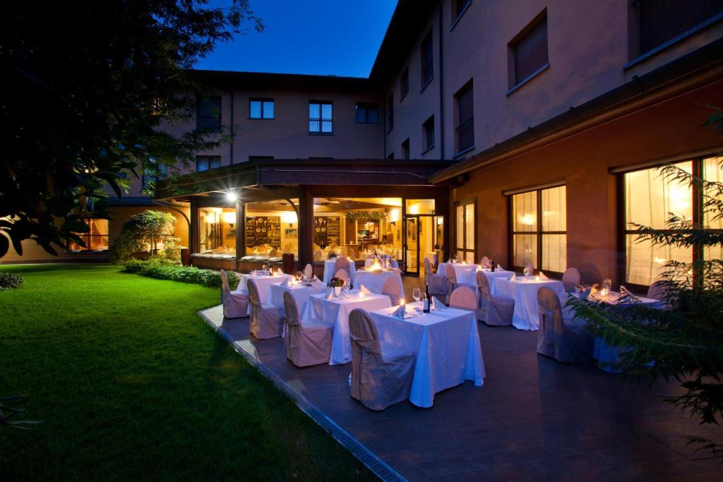 um grupo de mesas com panos de mesa brancos em Brianteo Hotel and Restaurant em Burago di Molgora