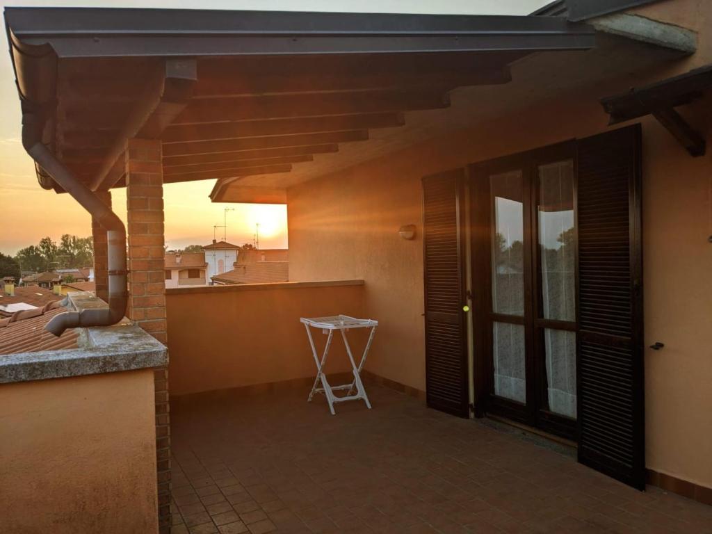 a porch of a house with a table and a stool at uno spazio luminoso e tranquillo vicino Milano in San Zenone al Lambro