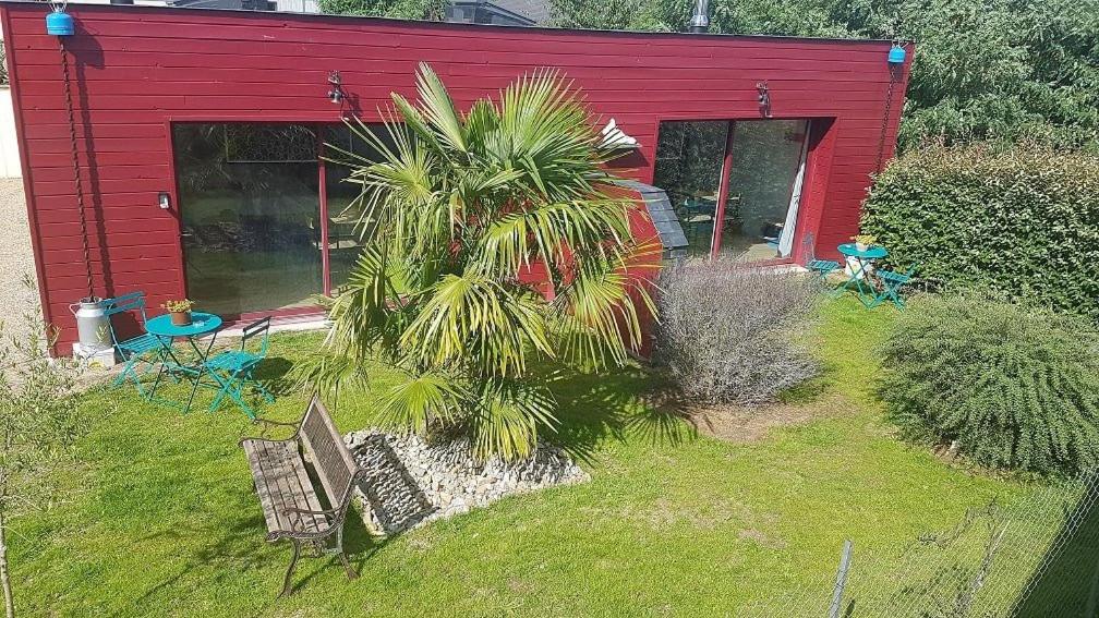 un bâtiment rouge avec deux chaises et un palmier dans l'établissement Test, à Lyon