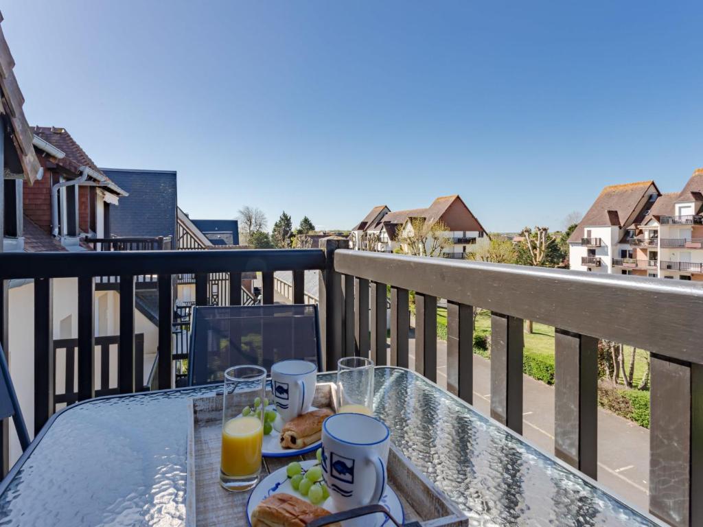 une table avec de la nourriture et des boissons sur un balcon dans l'établissement Apartment Fleur Marine-36 by Interhome, à Cabourg