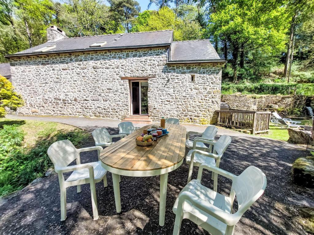 un tavolo e sedie di fronte a un edificio in pietra di Holiday Home La Meunière by Interhome a Le Gouray