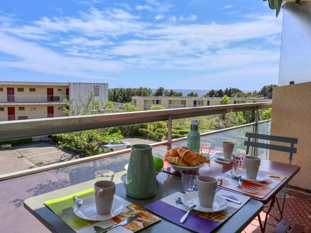 une table avec un bol de nourriture sur un balcon dans l'établissement Apartment Le Fidji-1 by Interhome, à La Ciotat