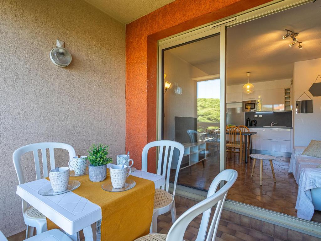 une salle à manger avec une table et des chaises blanches dans l'établissement Apartment Les Regates-7 by Interhome, à Hyères