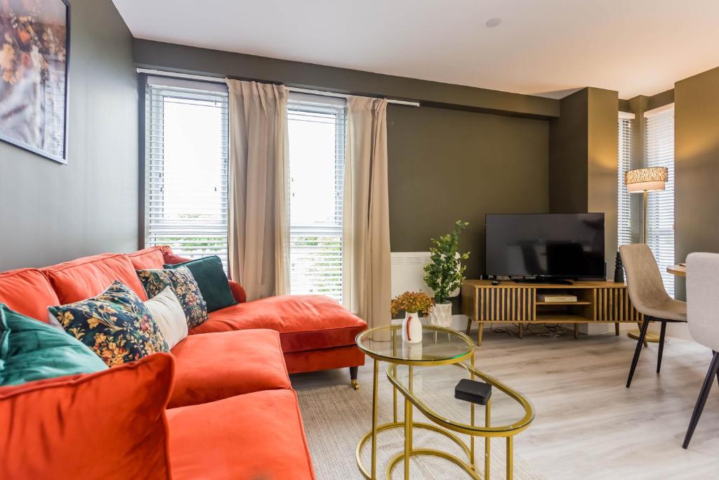 sala de estar con sofá naranja y TV en Parsons House, en Washington
