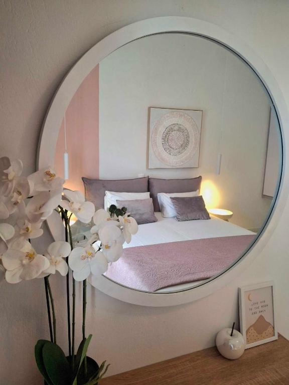 a bedroom with a bed in a round mirror at Philippos Apartments in Acharavi