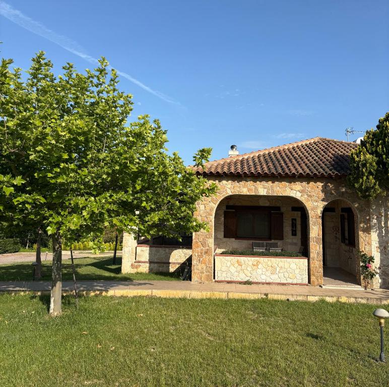 a stone house with a tree in a yard at Kappa Domus in Siviri