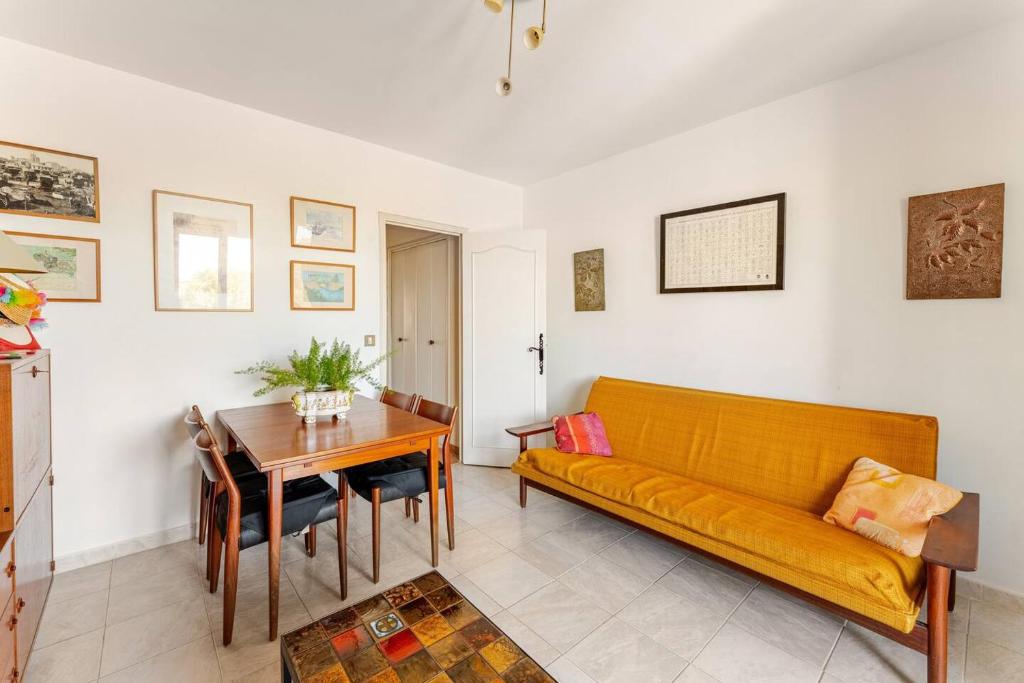 un salon avec un canapé jaune et une table dans l'établissement Appartement traversant vue sur l'étang, à Saintes-Maries-de-la-Mer