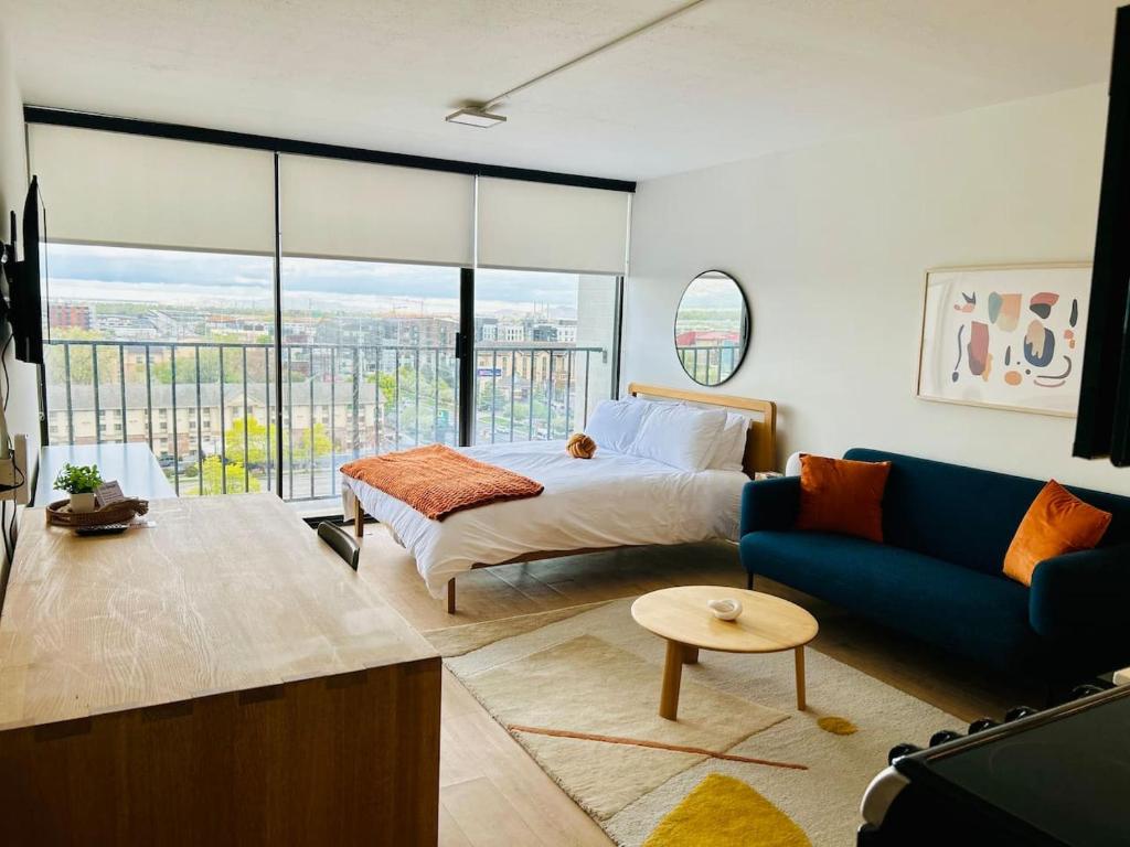 Un dormitorio con una cama y un sofá azul. en Downtown Cozy Vista DT Gym Free Parking, en Salt Lake City