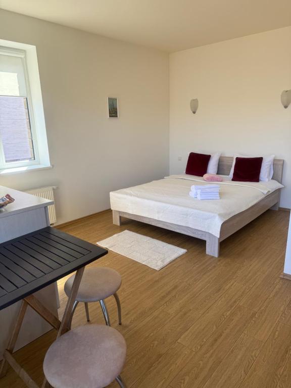 1 dormitorio con 1 cama, 1 mesa y 2 sillas en Palanga Old Town, en Palanga