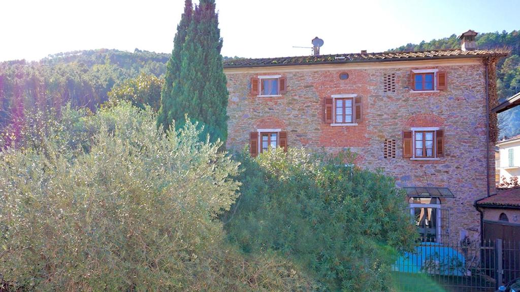 a large brick building with trees in front of it at Villa Vecchia Fontana al mare - Tra Liguria e Toscana tra Viaregggio, Forte dei Marmi e Cinque Terre- Haus am Meer bei la Spezia in Bocca di Magra