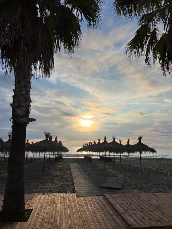 a beach with straw umbrellas and the ocean at Amelia apartments in Golem