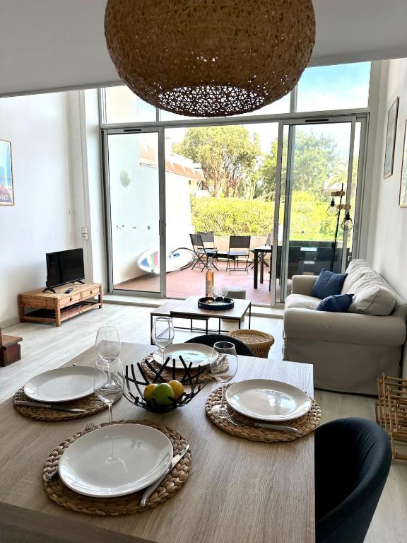 - un salon doté d'une table avec des assiettes et des verres à vin dans l'établissement Duplex Bord de Mer St Aygulf, à Fréjus