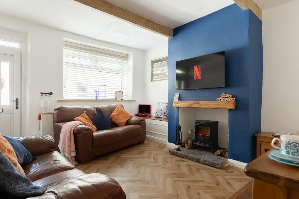 a living room with a couch and a fireplace at 'Haworth Haven', Warm Winter Cottage Getaway in Haworth