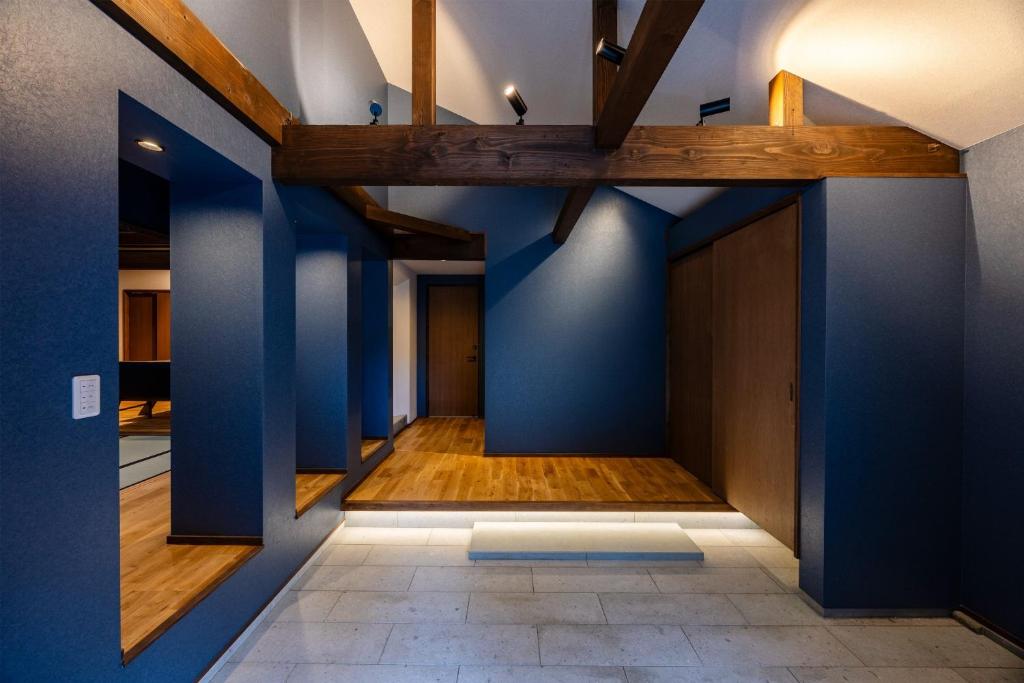a hallway with blue walls and wooden beams at Auberge S'Amuser - Vacation STAY 96495v in Sakai