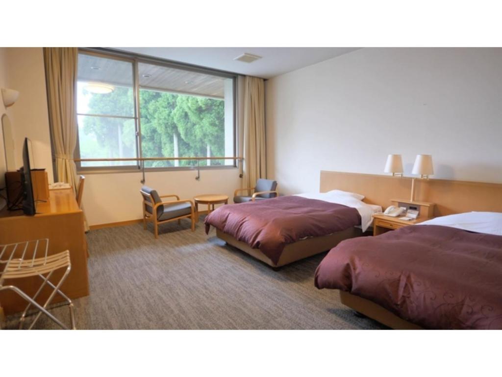a hotel room with two beds and a window at Tsujun Sanso - Vacation STAY 11979v in Yamato