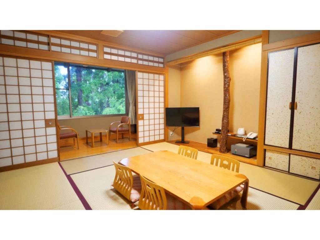 a room with a table and chairs and a television at Tsujun Sanso - Vacation STAY 11962v in Yamato