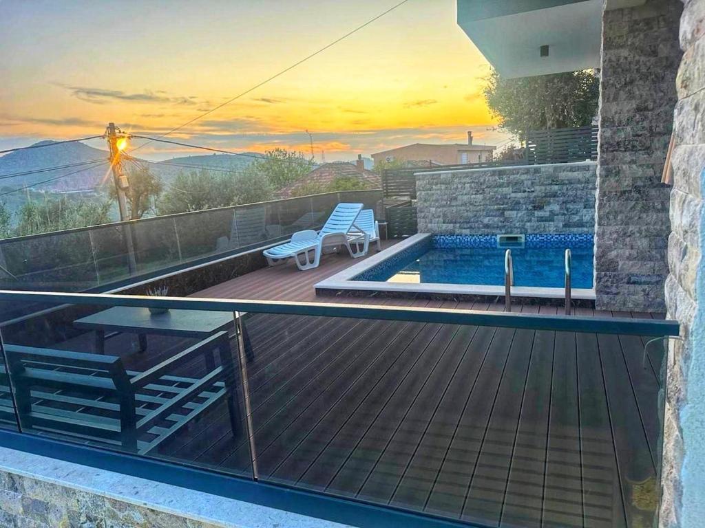 a house with a balcony with a pool and a sunset at Villa Nova Bar in Zaljevo