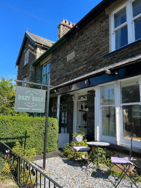 a shop with a sign in front of a building at The Dozy Deer in Windermere