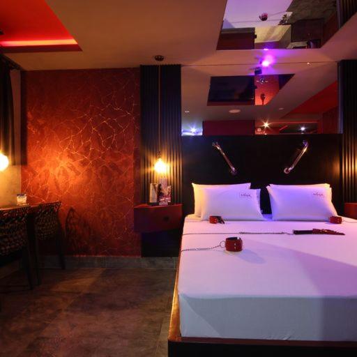 a bedroom with a large white bed with purple lights at Misk Motel in Anhumas