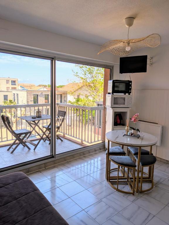 - un salon avec vue sur un balcon dans l'établissement Appartement Valras - Bord de mer, à Valras-Plage