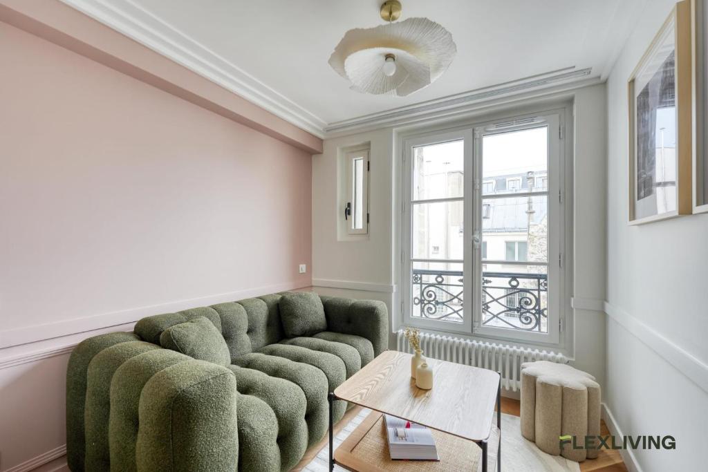 un salon avec un canapé vert et une fenêtre dans l'établissement Charming 2-bedroom with living room 47 m Paris 9e, à Paris