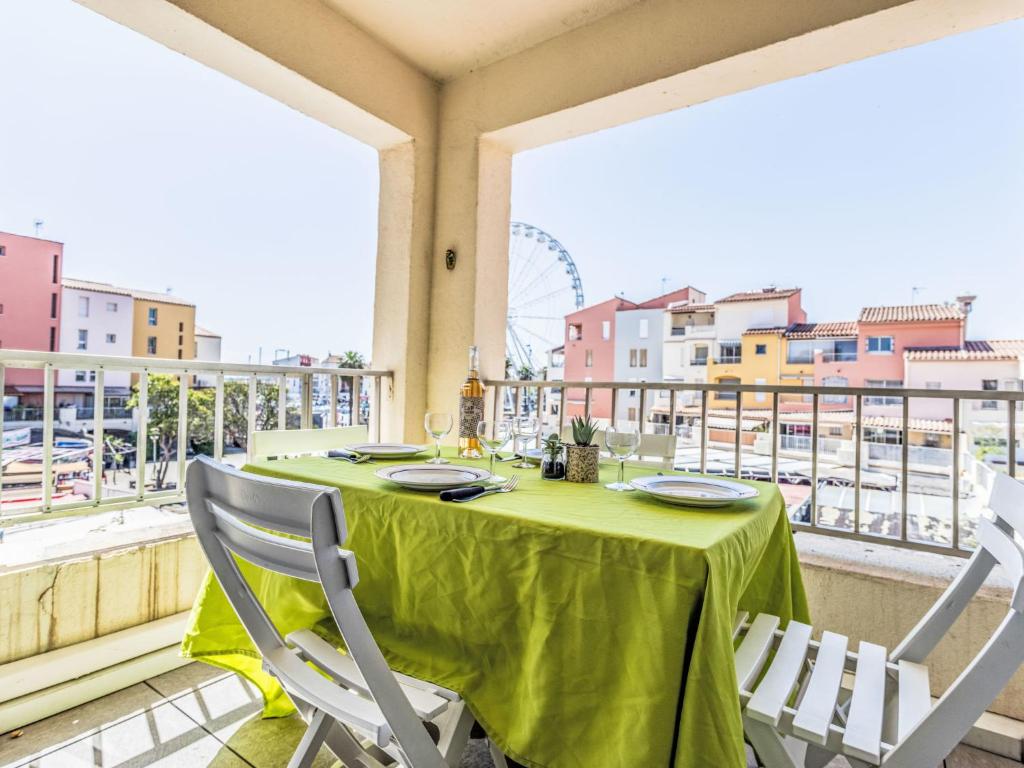 une table avec un tissu de table vert sur un balcon dans l'établissement Apartment Port Richelieu 1 by Interhome, au Cap d'Agde