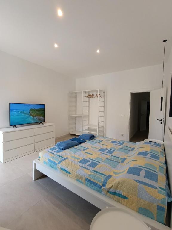 a bedroom with a bed and a flat screen tv at Borgata Relax in Syracuse