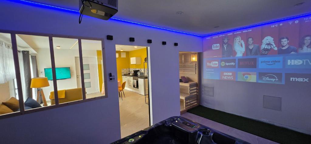 une pièce avec un mur violet avec un écran vidéo dans l'établissement Le Rêve SPA Sauna, cinéma Colmar, à Muntzenheim