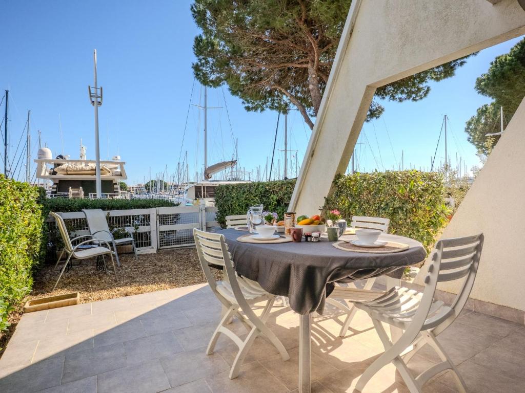 une table et des chaises sur une terrasse avec vue sur une marina dans l'établissement Apartment Les Rivages d'Ulysse by Interhome, au Grau-du-Roi