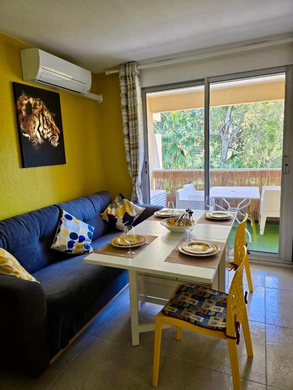 un salon avec une table et un canapé bleu dans l'établissement Le Boulouris - stylish T2, à Saint-Raphaël