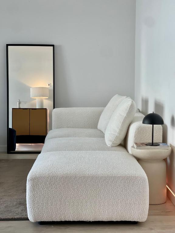 a white couch in a living room with a mirror at San Fermin Centro II in Pamplona
