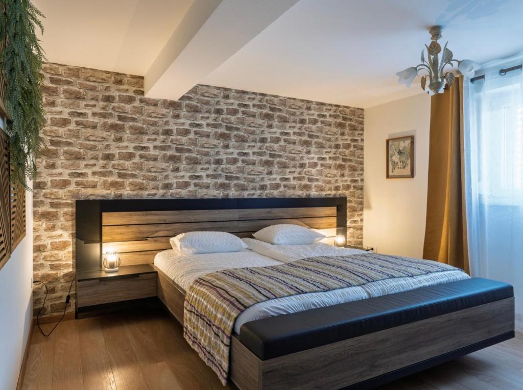 une chambre avec un mur de briques et un lit dans l'établissement Gîte Bagatelle l'Ecrin du Ried PROCHE EUROPAPARK, à Artolsheim