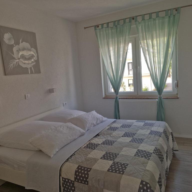 a bedroom with a bed and a window at Vila Natasa Apartment 4 near Plitvice in Vrhovine