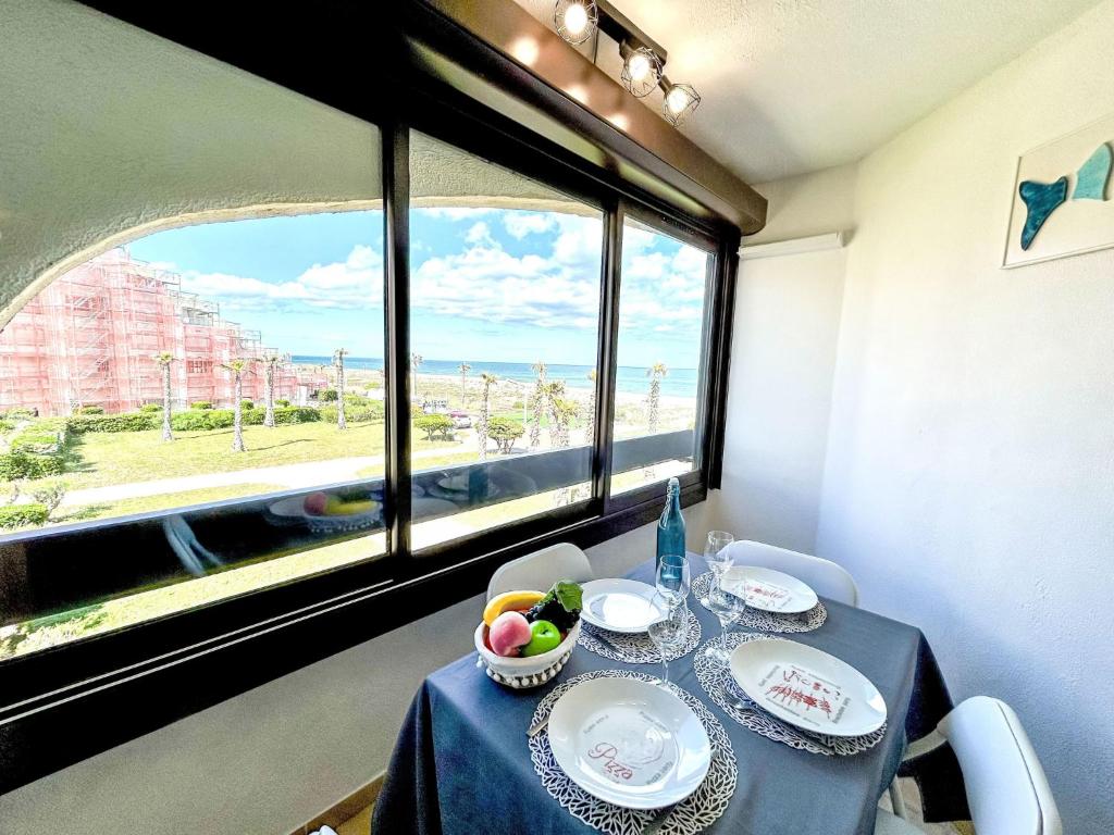 une salle à manger avec une table et une fenêtre dans l'établissement Apartment Front de Mer-26 by Interhome, au Barcarès