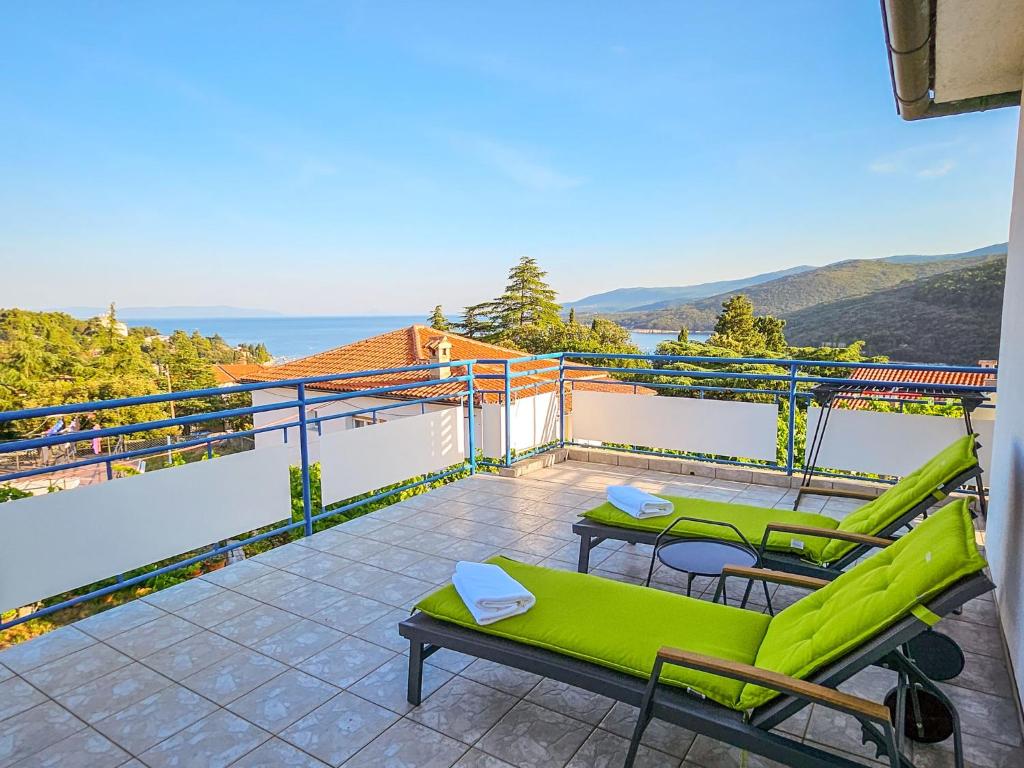 a balcony with green furniture and a view of the ocean at Apartment Lorber by Interhome in Rabac