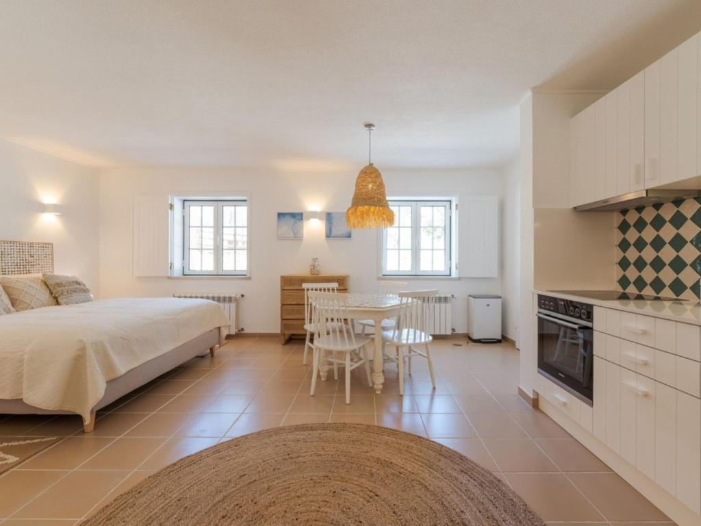 a bedroom with a bed and a table and a kitchen at Apartment Natura Bliss Studio by Interhome in Alcácer do Sal