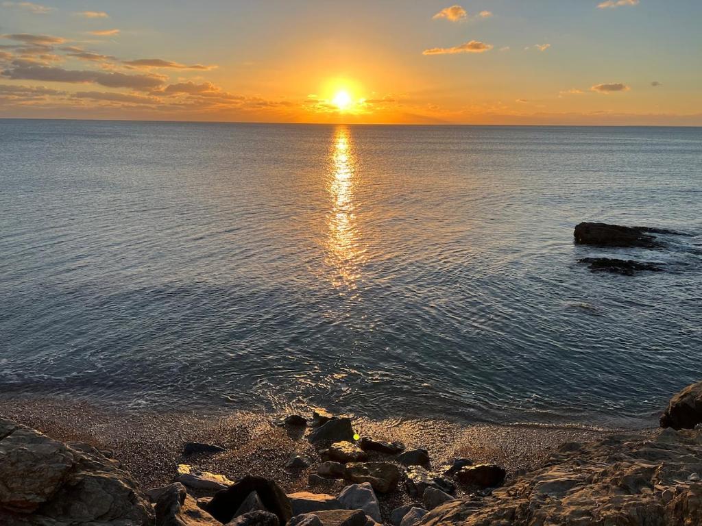un coucher de soleil sur une étendue d'eau avec des rochers dans l'établissement Refuge sur la corniche ! 5 minutes de St-Gilles, à Saint-Hilaire-de-Riez