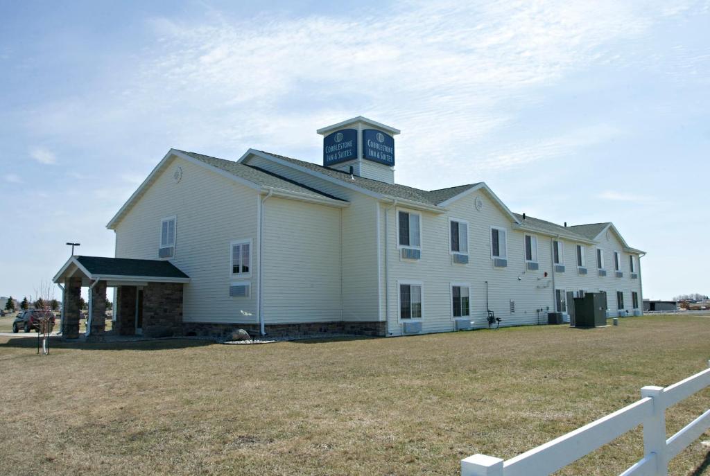 a large white building with a clock tower on top at Cobblestone Inn & Suites - Langdon in Langdon