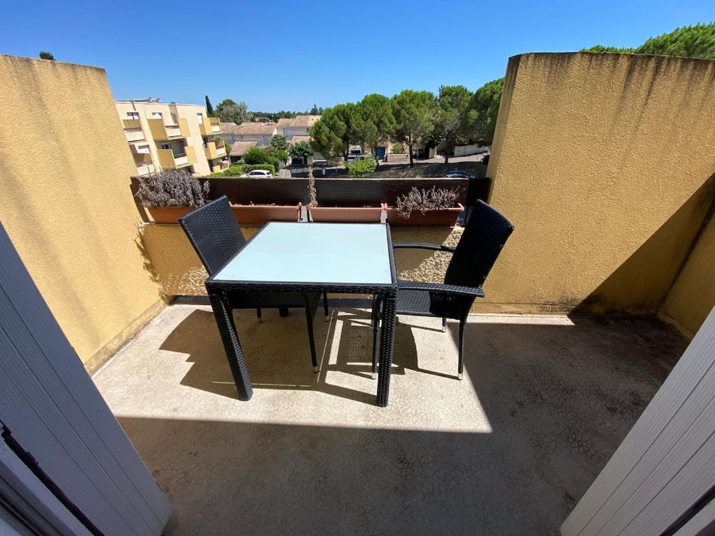 une table et deux chaises sur un balcon dans l'établissement Grand et Cosy T2 à 10min des facultés, à Montpellier