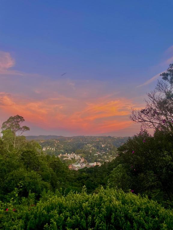 a view of a sunset from a hill with trees at Villa Panorama in Campos do Jordão