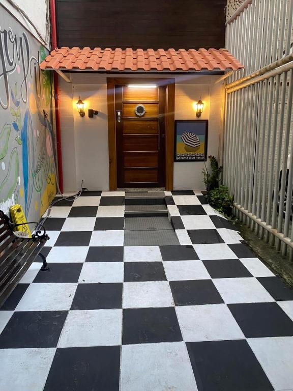 a black and white checkered floor in front of a door at Ipanema Club Hostel in Rio de Janeiro
