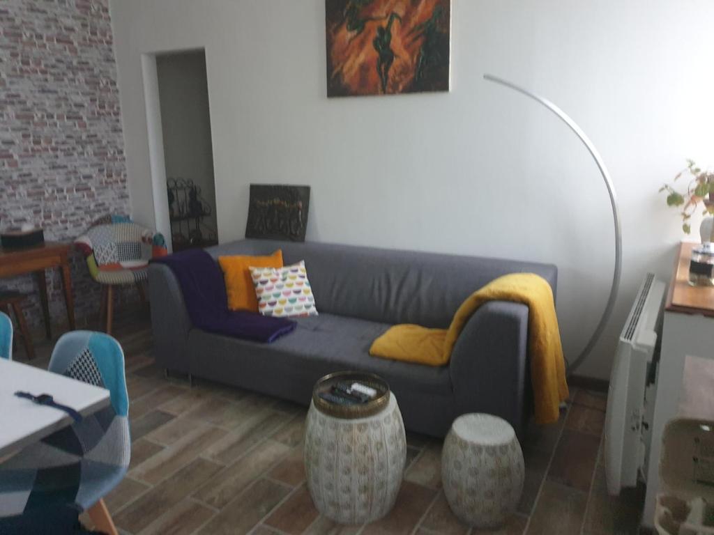 un salon avec un canapé bleu et une table dans l'établissement Une petite campagne en ville, au Mans