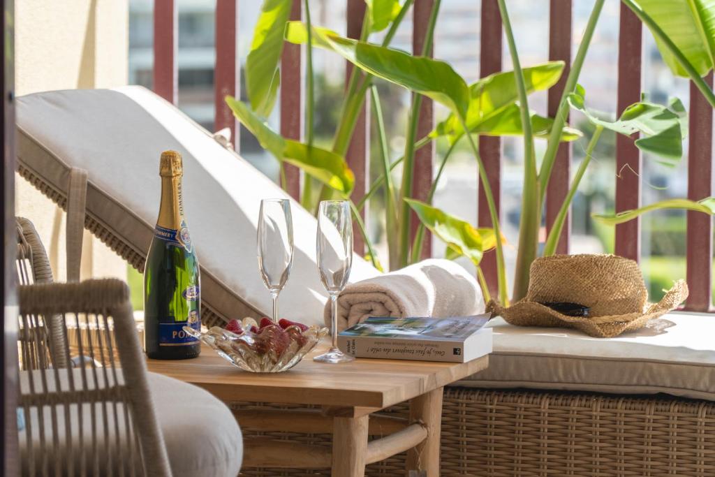 a table with a bottle of wine and glasses on a porch at Sea Breeze in Portimão