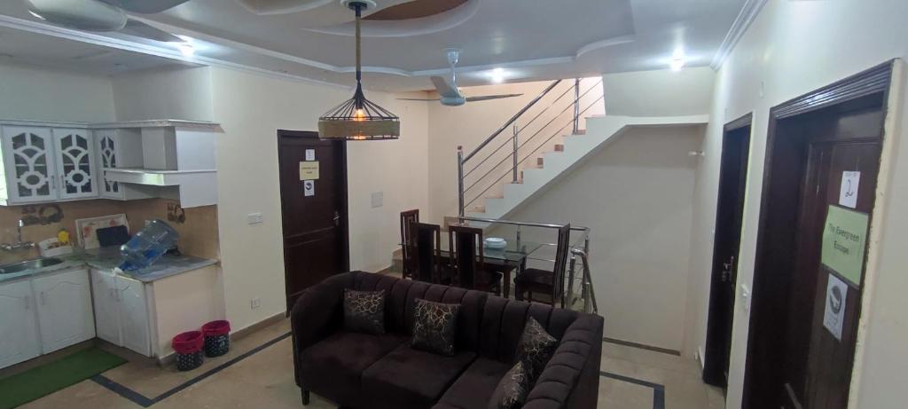 Una sala de estar con un sofá y una escalera. en Evergreen Escape, en Lahore