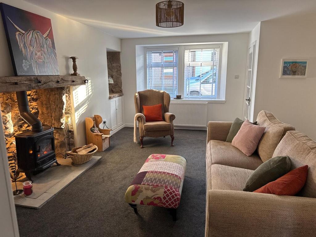 a living room with a couch and a fireplace at Cosy Wee Cottage in Monkton