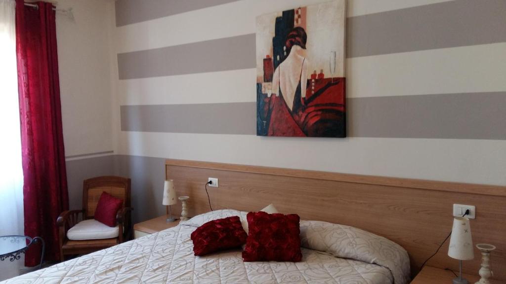 a bedroom with a bed with two red pillows on it at Locanda alla Chiesa in Lazise